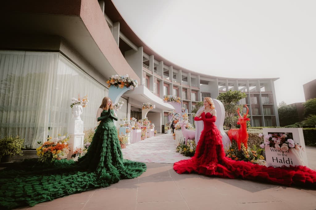 Grand red and green gowns outside venue