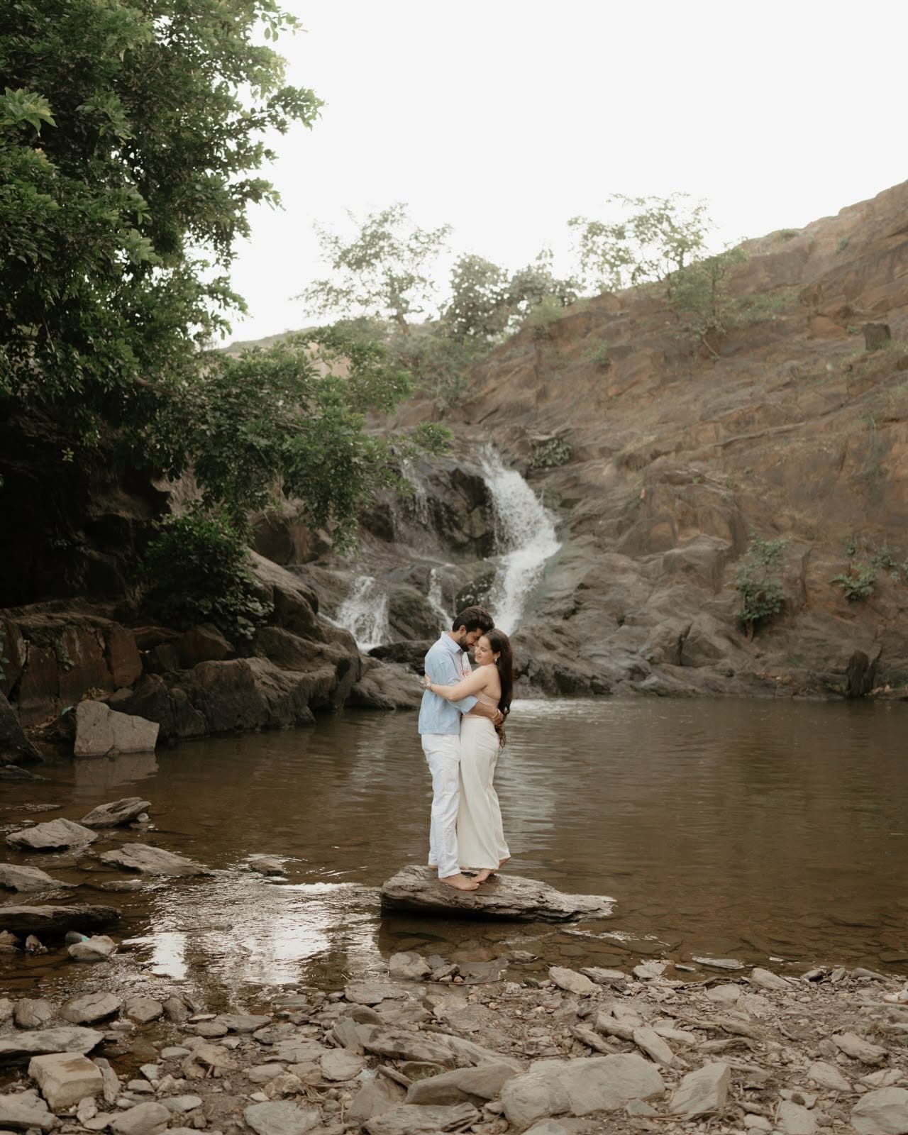 Couple sharing intimate romantic moment against ancient sandstone heritage fort walls