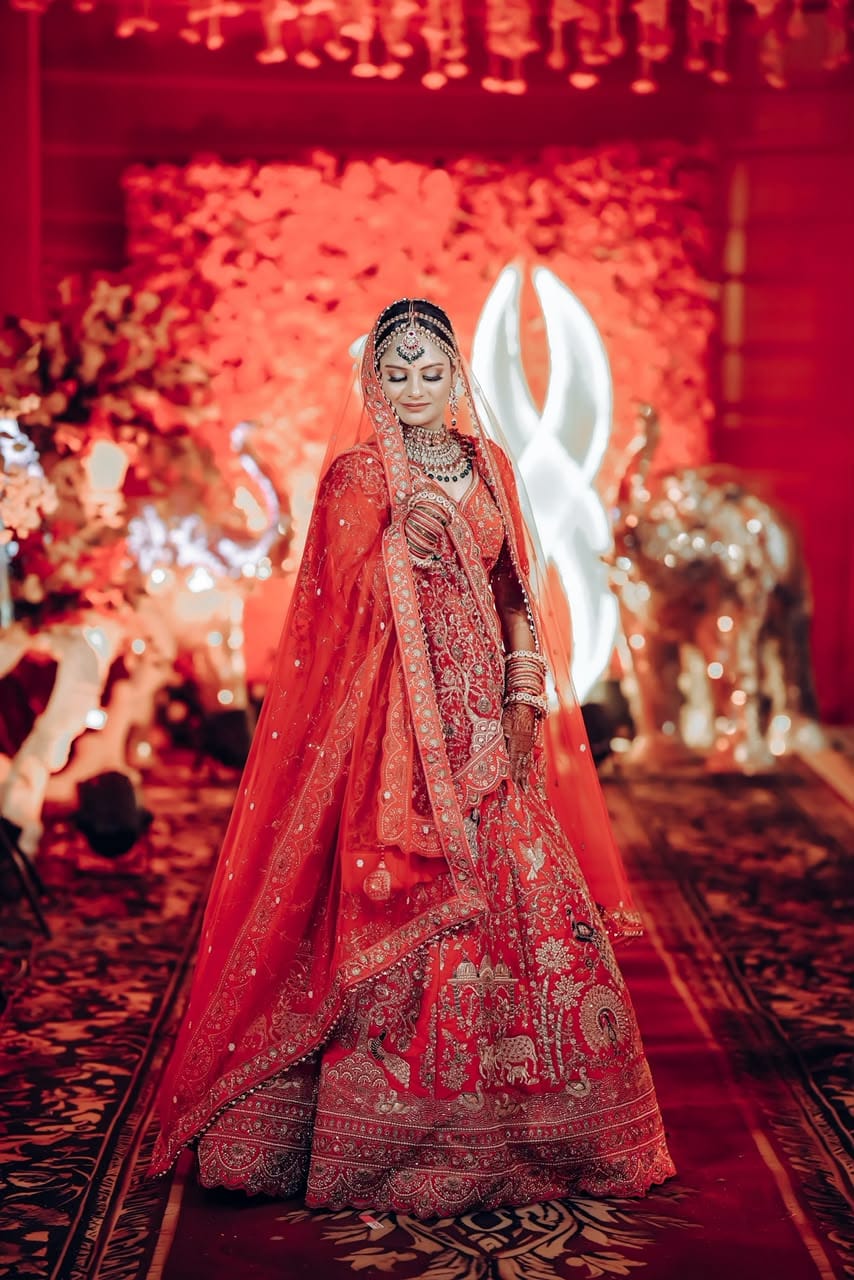 Traditional bride adorned in traditional gold jewelry smiling during sacred ceremony